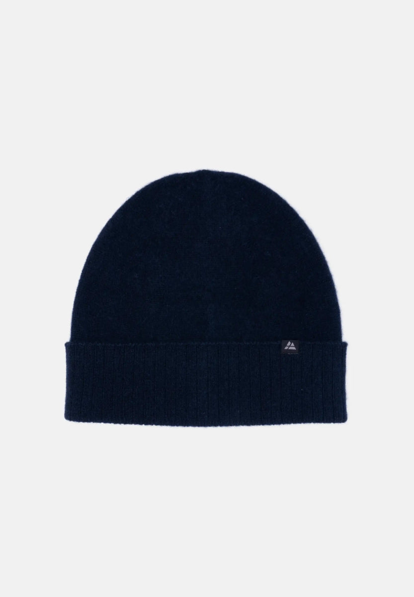 Dark navy cashmere beanie with ribbed cuff and small logo tag on a light background.