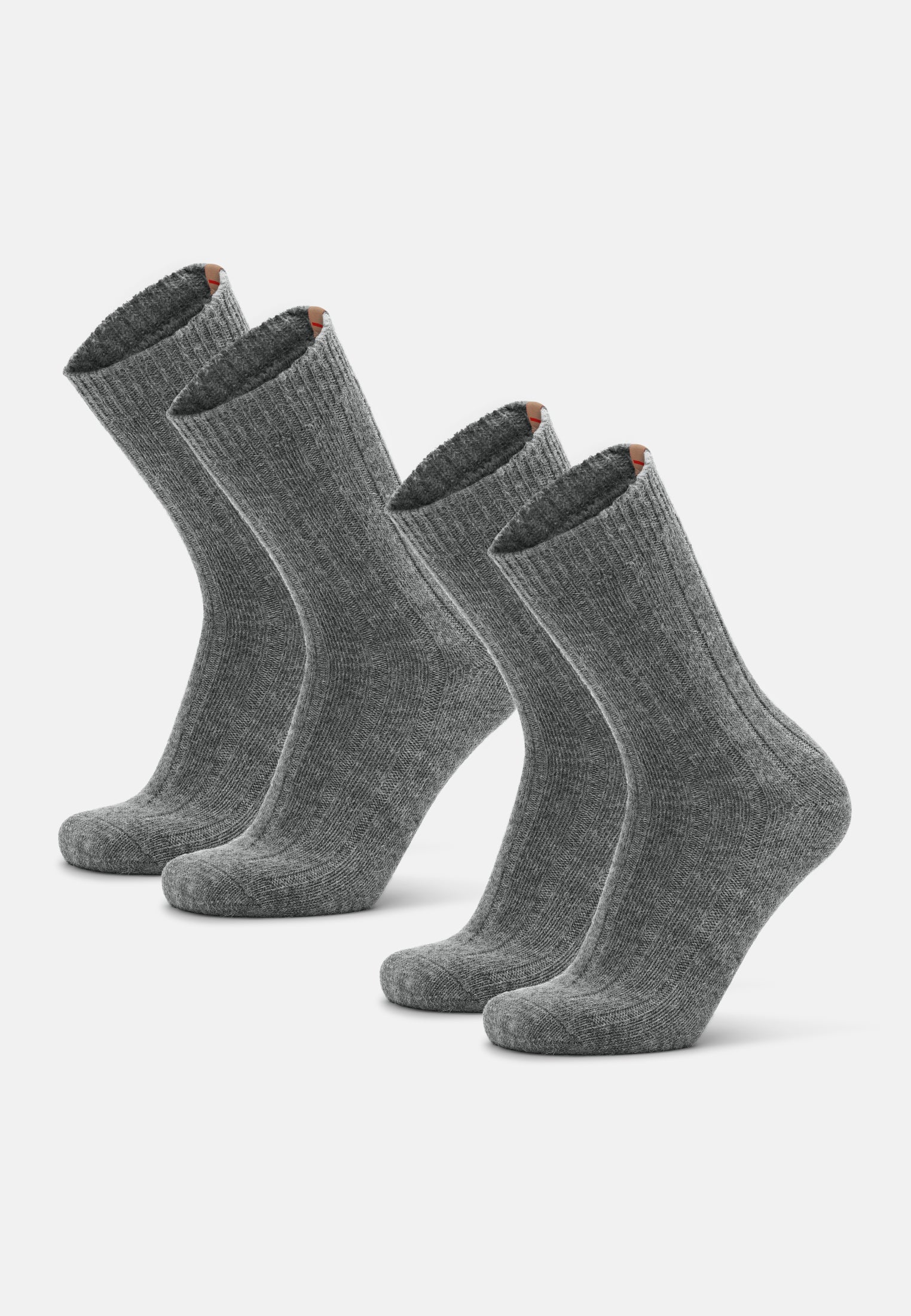 Four gray alpaca wool socks standing upright on a white background.
