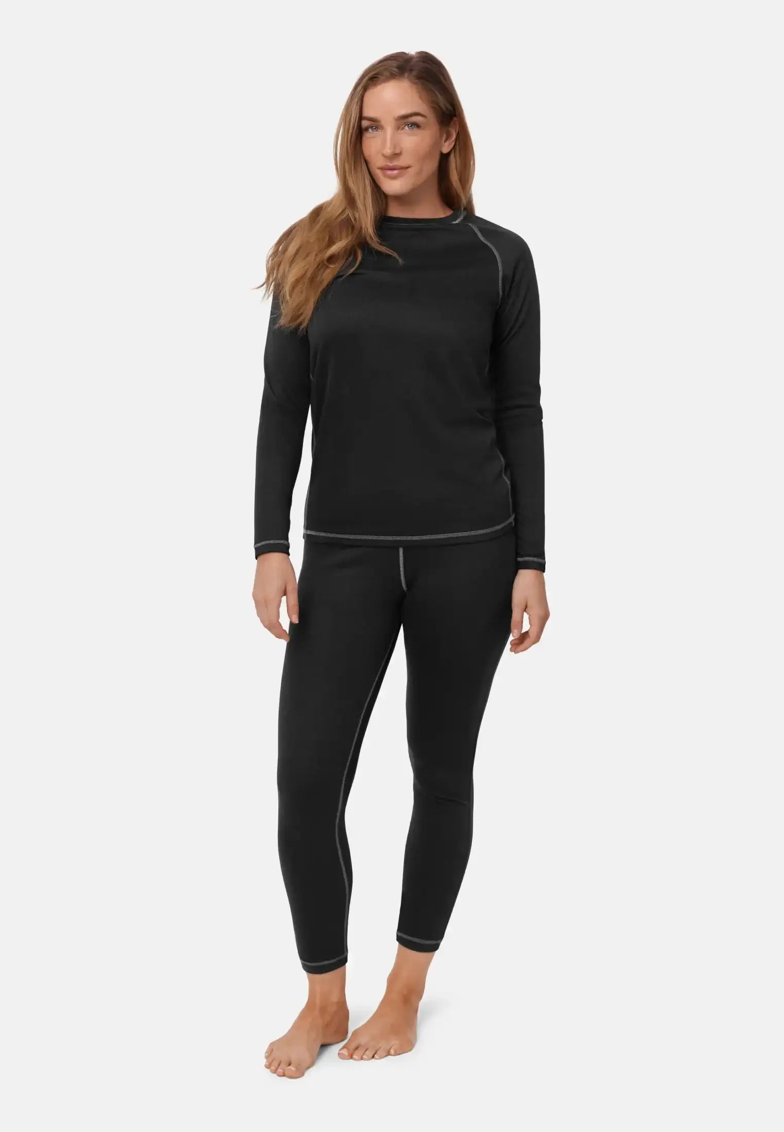 Person wearing black thermal underwear set with long sleeves and leggings, showing visible seams.
