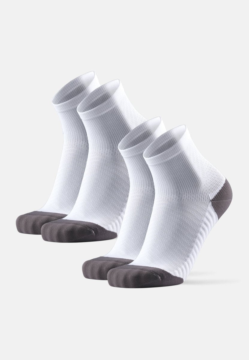 Four pairs of white ankle socks with dark gray toes and heels, designed for anti-slip running.
