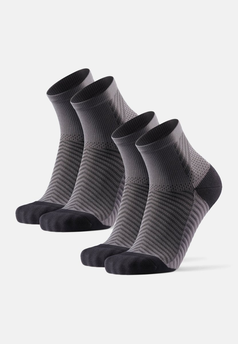 Four pairs of dark gray and black ankle-length running socks with ribbed cuffs displayed.