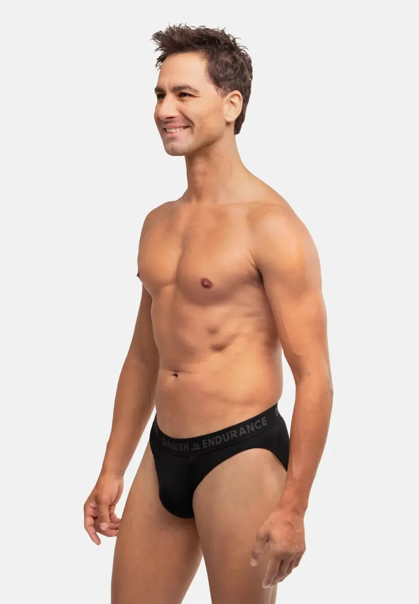 Man wearing black DANISH ENDURANCE briefs, standing sideways against a plain background.