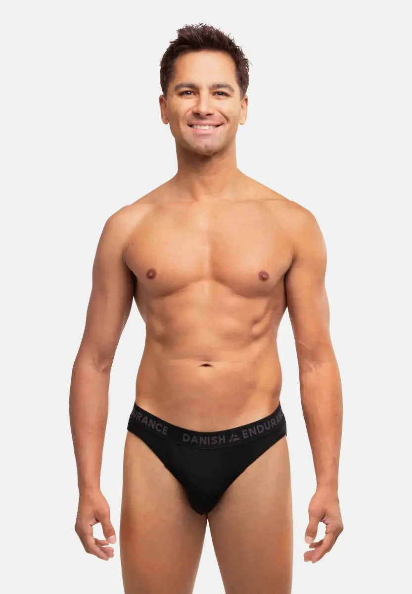 Man wearing black bamboo briefs with "Danish Endurance" waistband, standing against a white background.