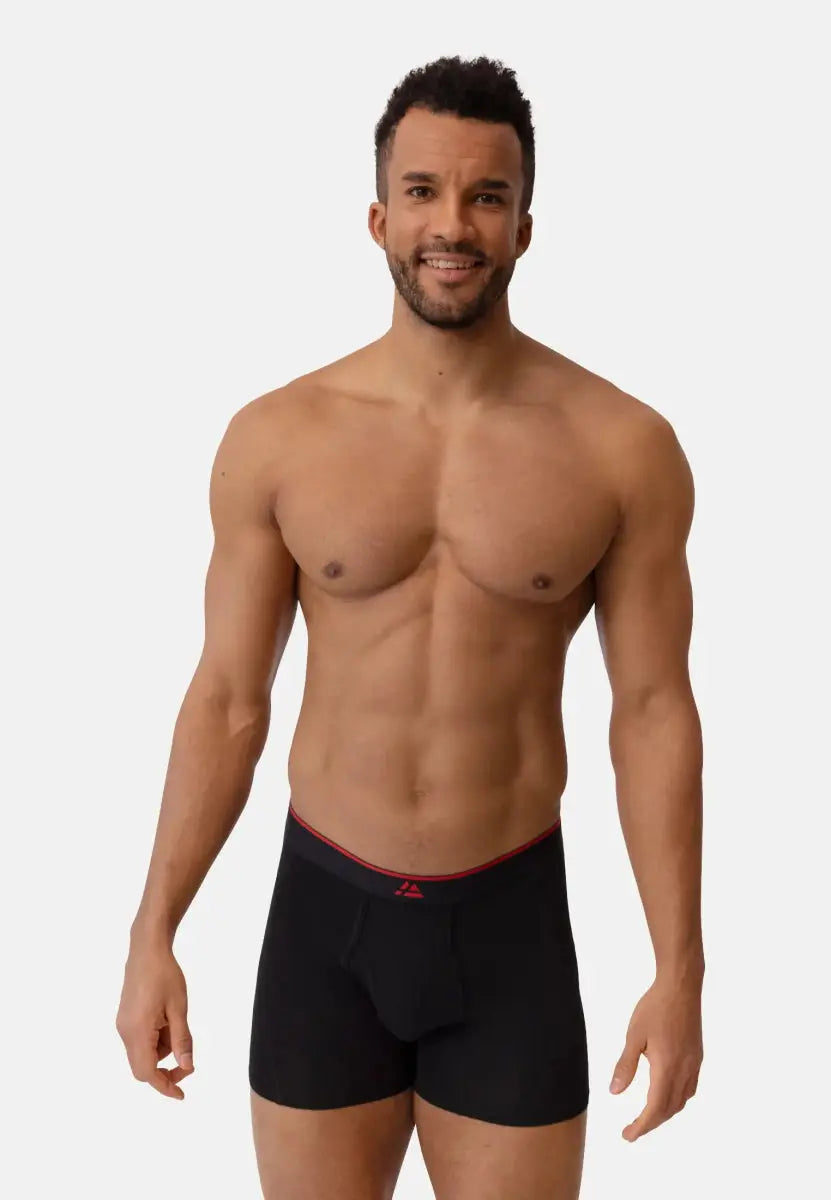 Man wearing black bamboo trunks with a red waistband and fly, standing against a plain background.