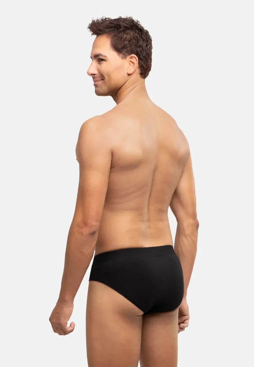 Person wearing black cotton briefs, shown from the back, highlighting fit and comfort.