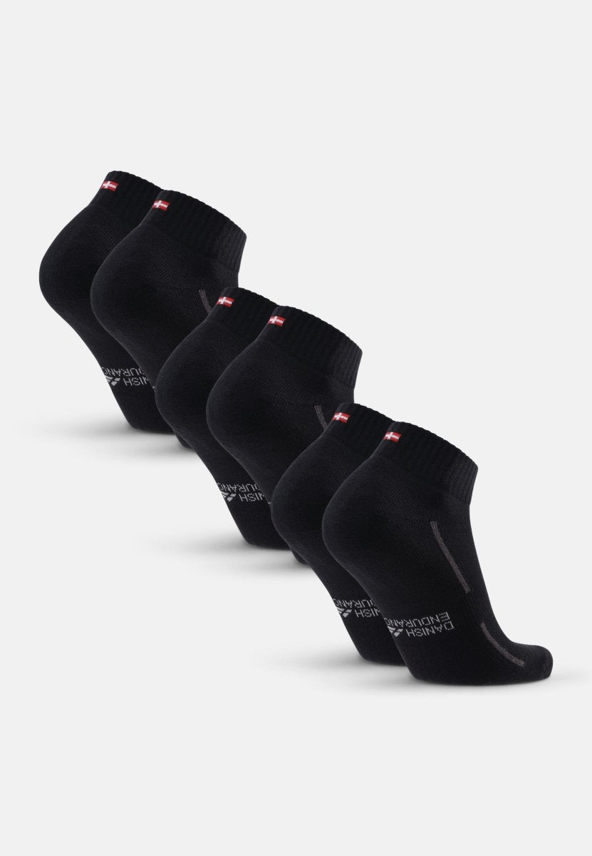 Four pairs of black cotton quarter socks with red and white tags, arranged in a row.