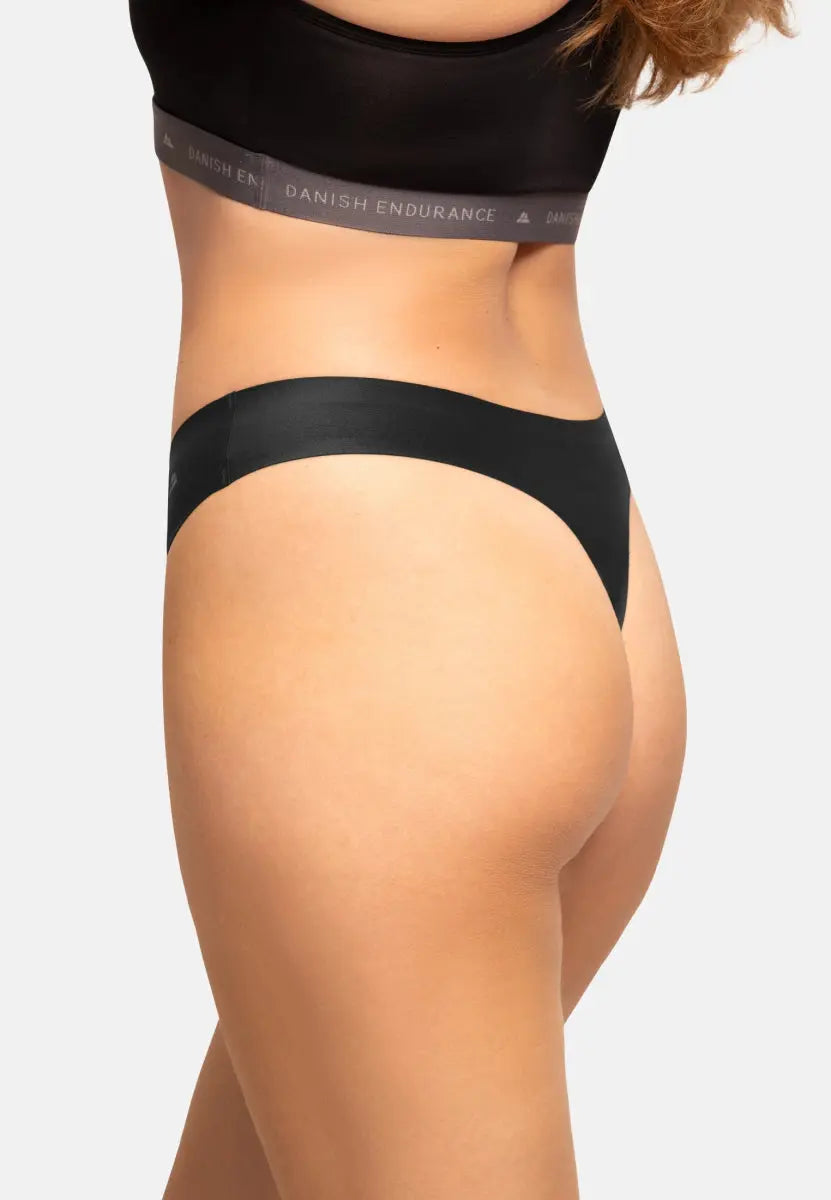 Close-up of black invisible thong panties with a black waistband on a person.