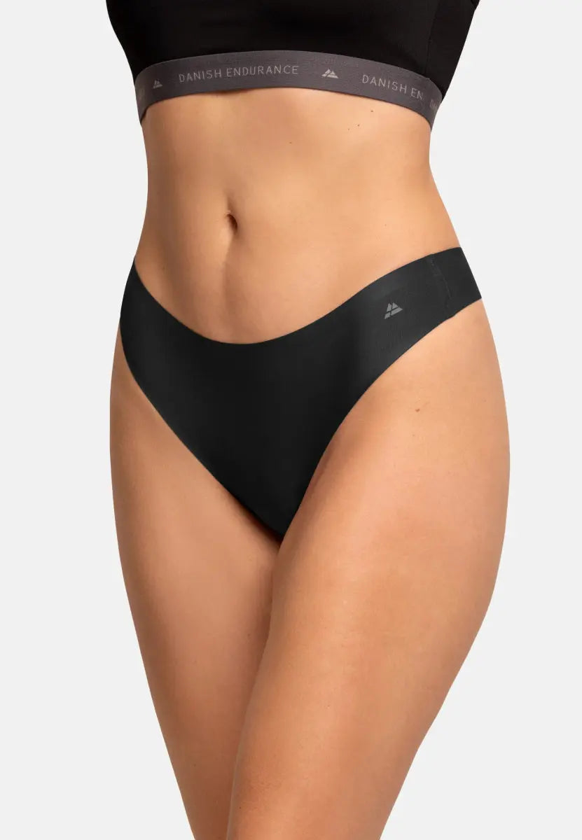 Close-up of person wearing black invisible thong panties, showing seamless design and fit.