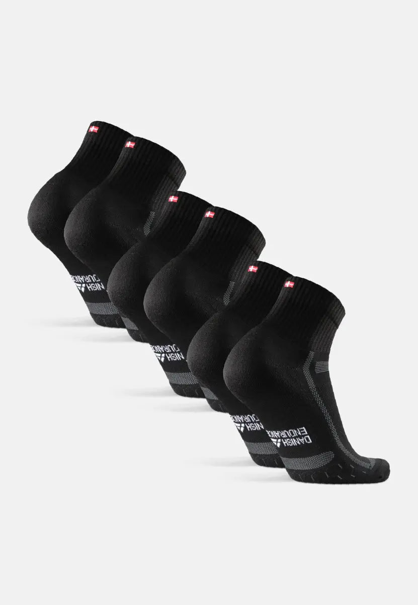 Five pairs of black kids' running socks with extra padding, featuring a red and white emblem.