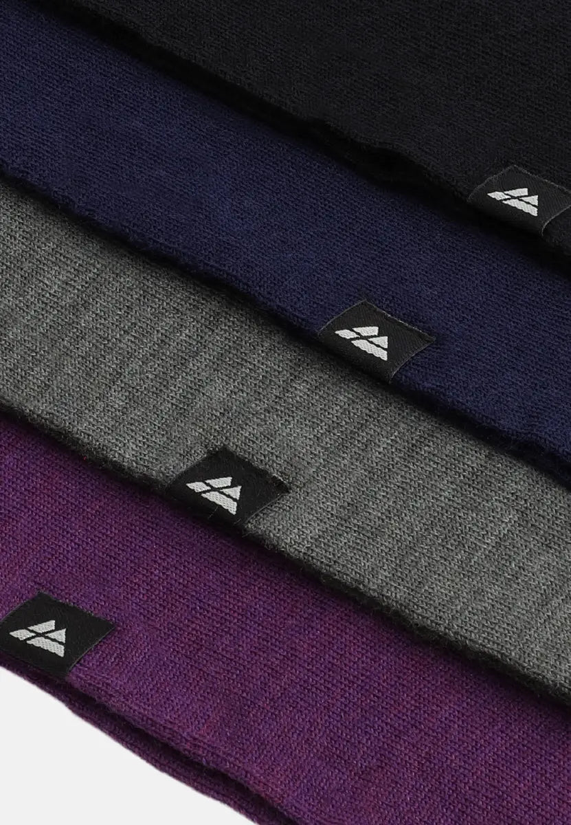 Four merino headbands in black, navy, gray, and purple, with logo tags.
