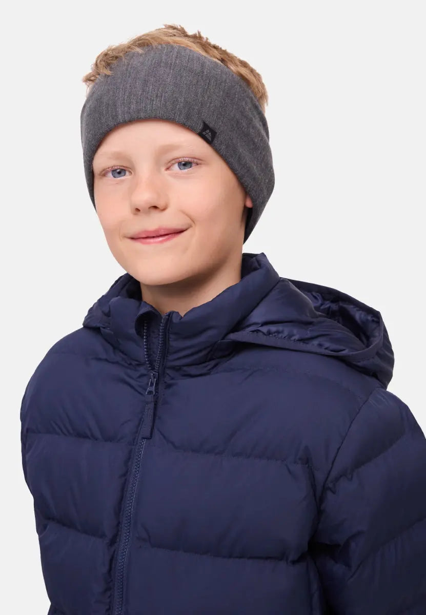 Child in gray merino headband and navy puffer jacket, smiling gently against a plain background.