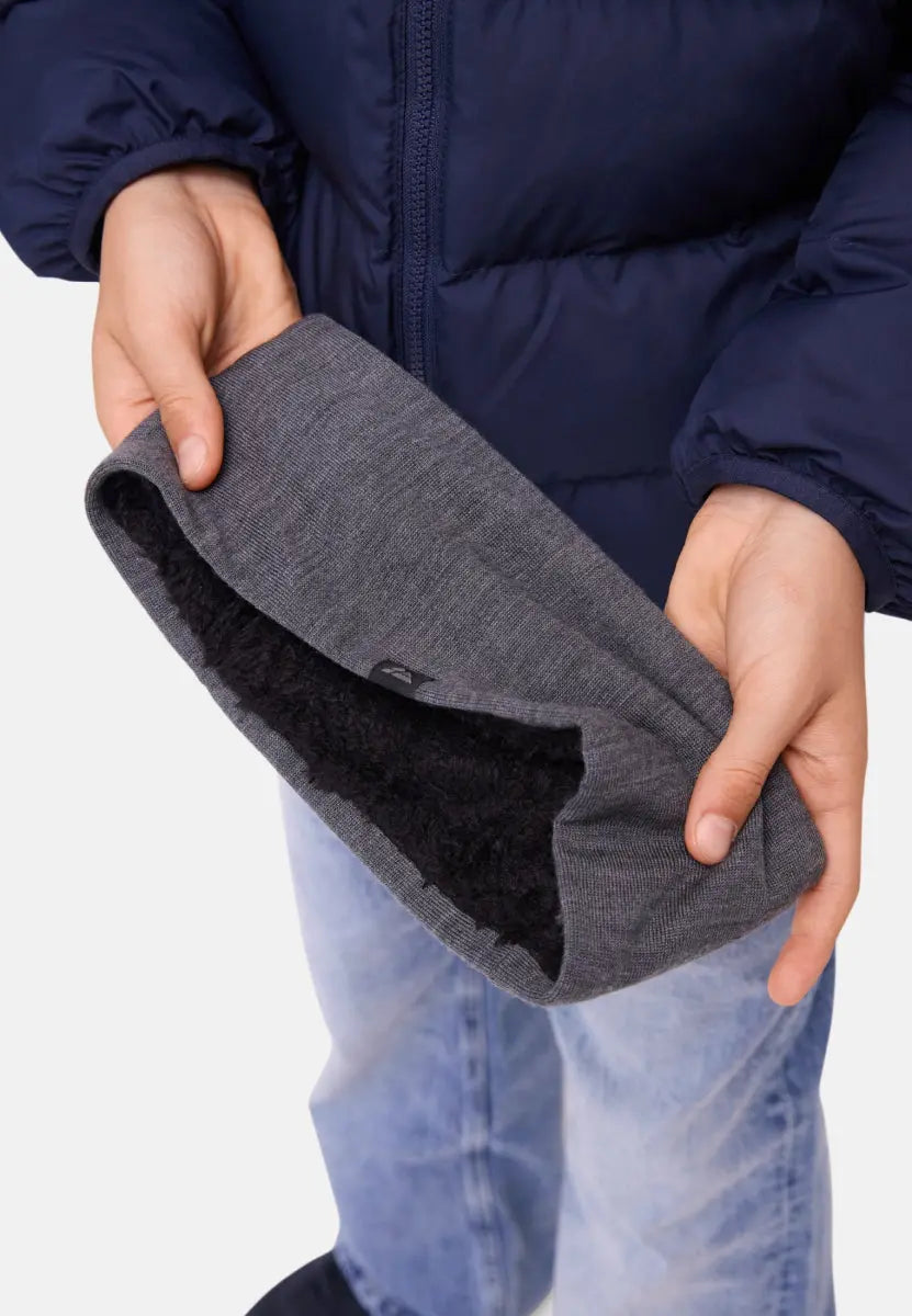 Child in a blue jacket holding a gray merino headband with black fleece lining.