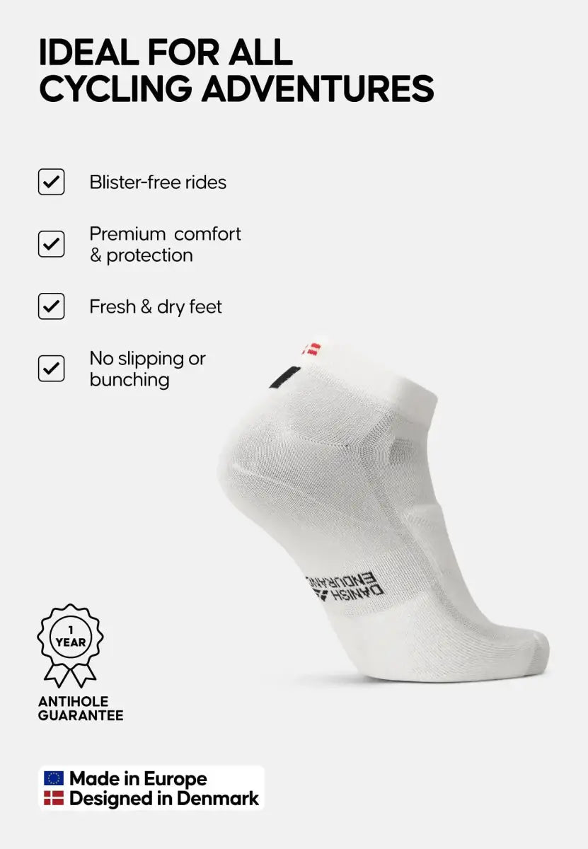 White low-cut cycling socks with benefits listed: blister-free, comfort, dry, no slipping, Danish design.