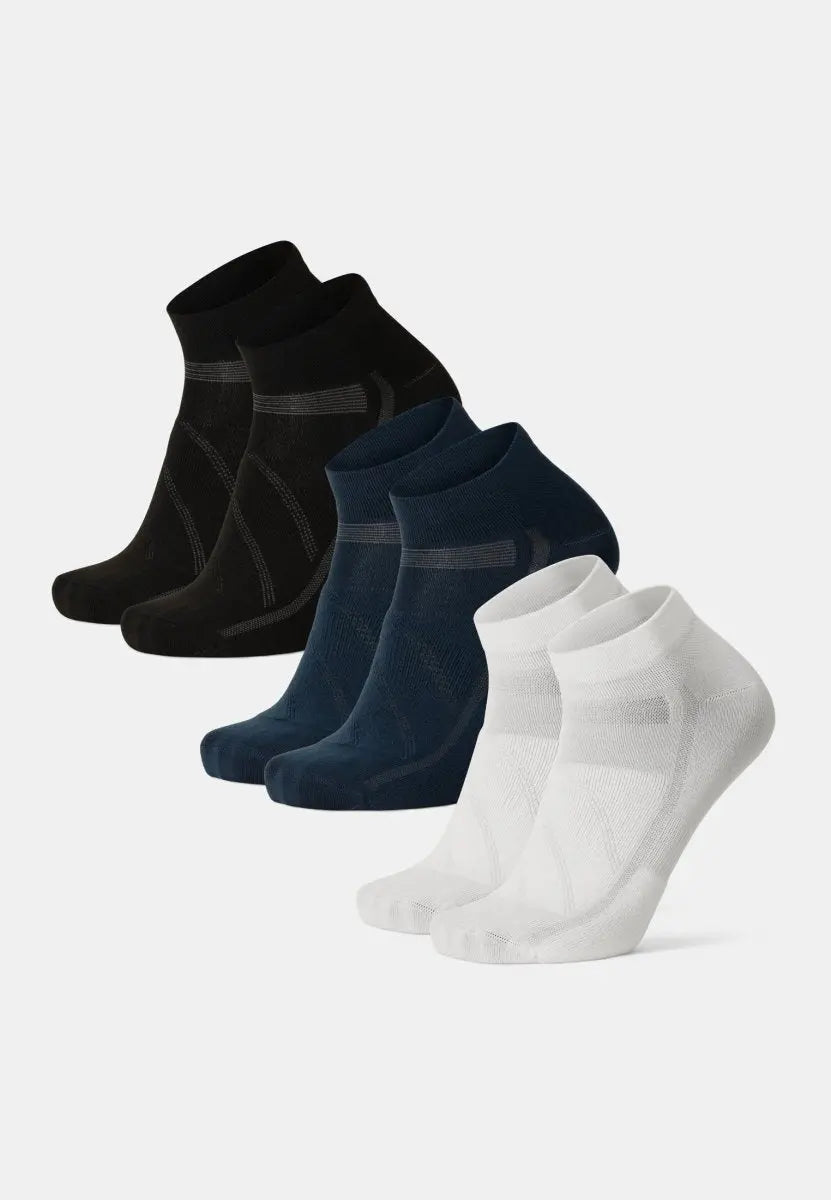 Three pairs of low-cut cycling socks in black, navy, and white, neatly arranged.