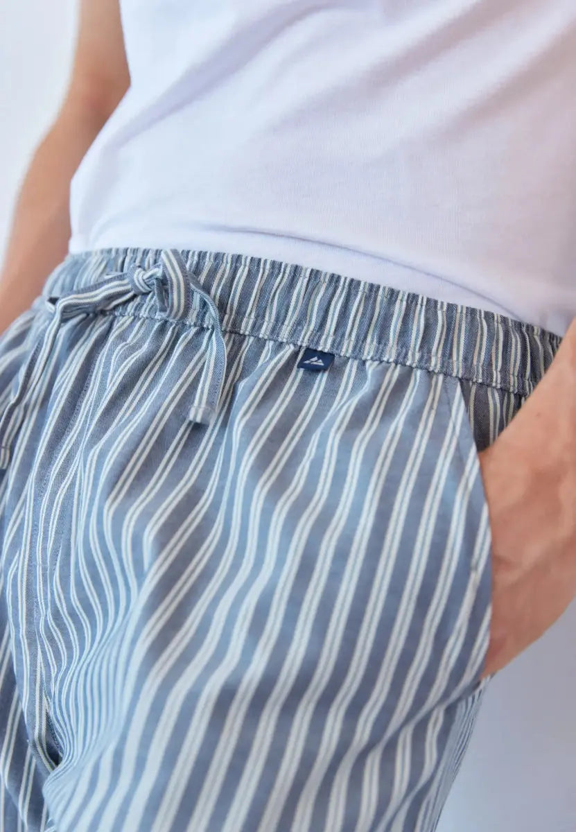 Close-up of blue and white striped men's pajama pants with drawstring and side pocket.