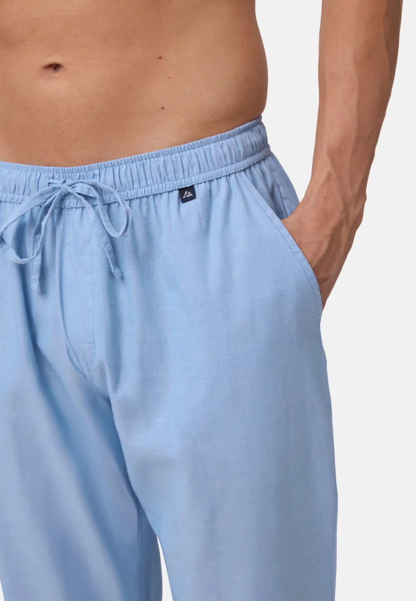 Light blue men's pyjama pants with drawstring and pocket, worn by a person with visible torso.