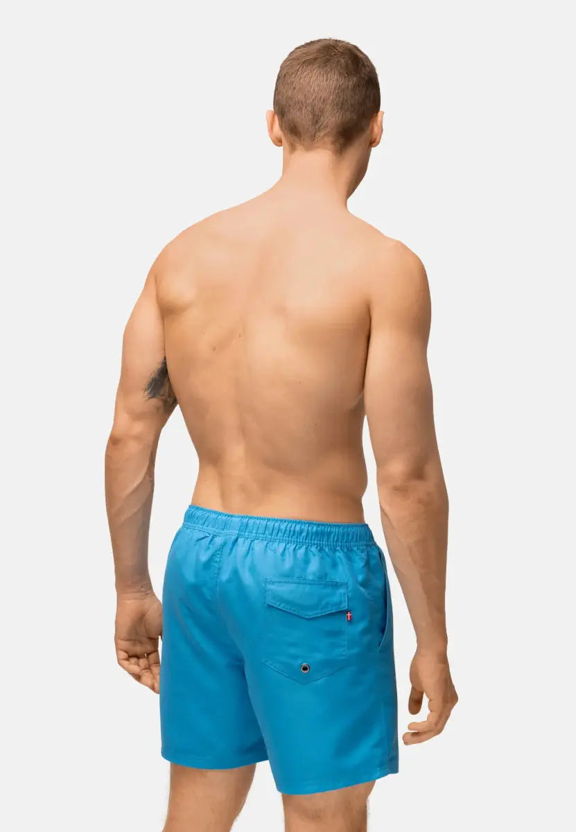 Shirtless man wearing blue quick-dry swim trunks with a back pocket, viewed from behind.