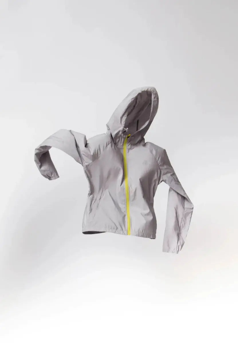 Light gray windbreaker jacket with hood and yellow zipper, displayed mid-air.