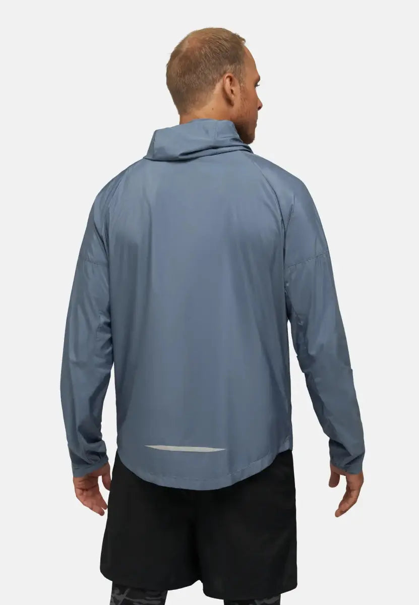 Man wearing a light blue windbreaker jacket with a high collar, seen from the back.