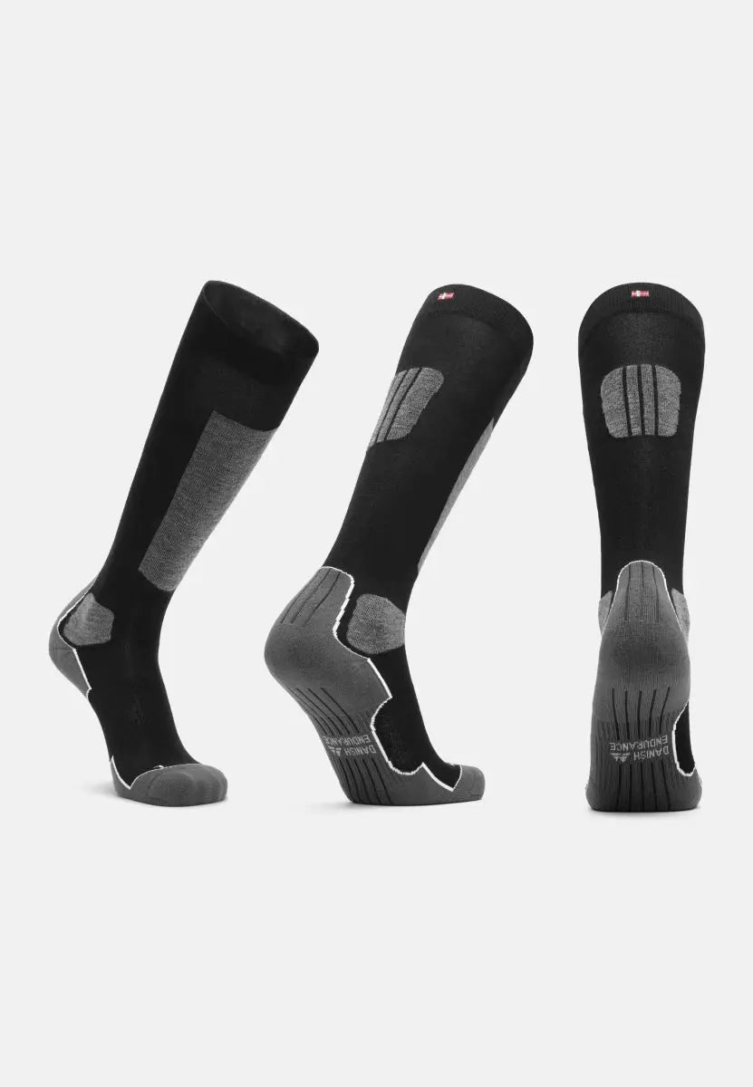Three black and gray knee-high ski socks with cushioning and branding, shown from different angles.