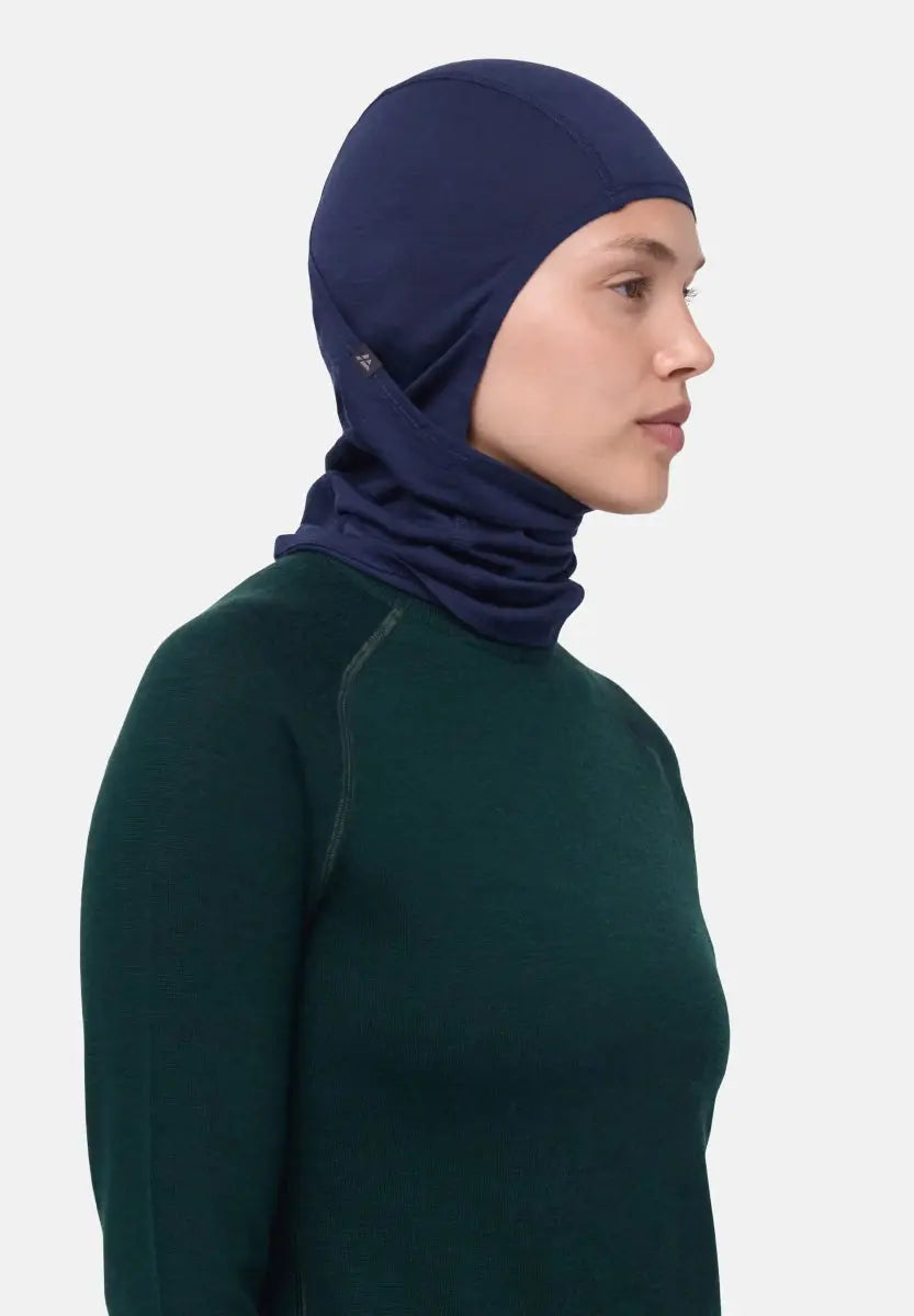 Person in navy balaclava and dark green top, side profile view.
