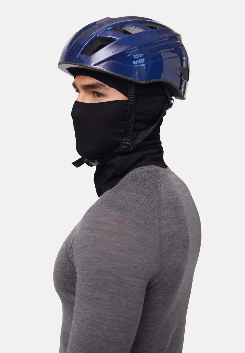 Person in a black balaclava and blue helmet, wearing a gray shirt, side profile view.