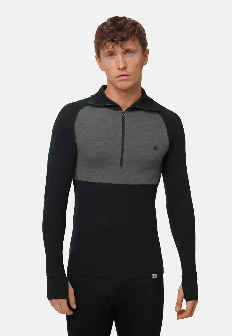 Man wearing a two-tone, black and gray merino wool half-zip shirt, long sleeves, standing front-facing.