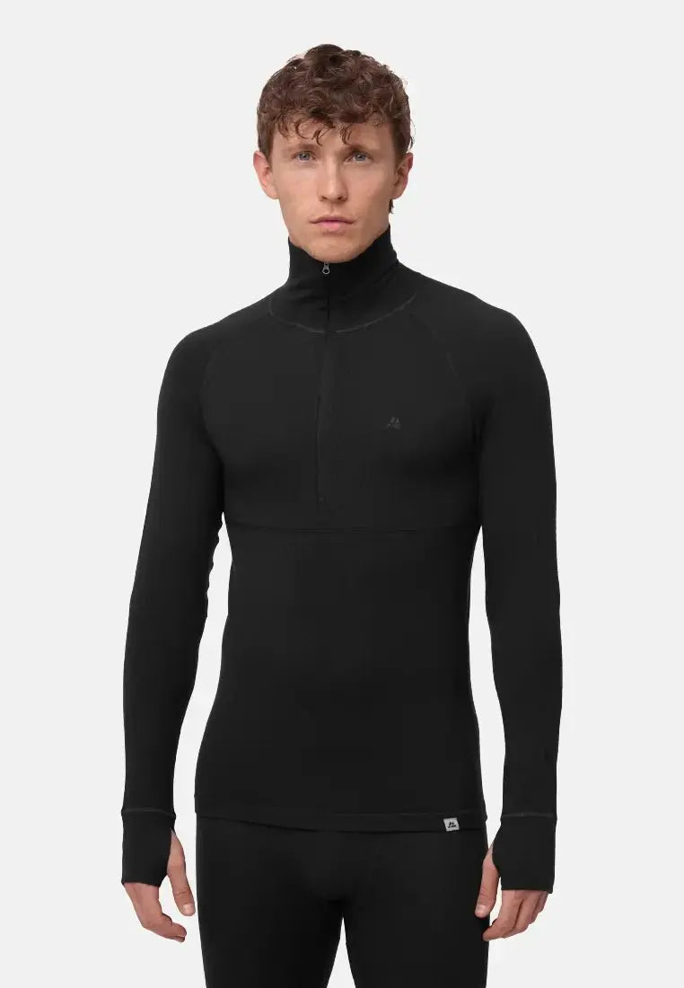 Man wearing black merino wool half-zip base layer shirt, long sleeves, standing against white background.