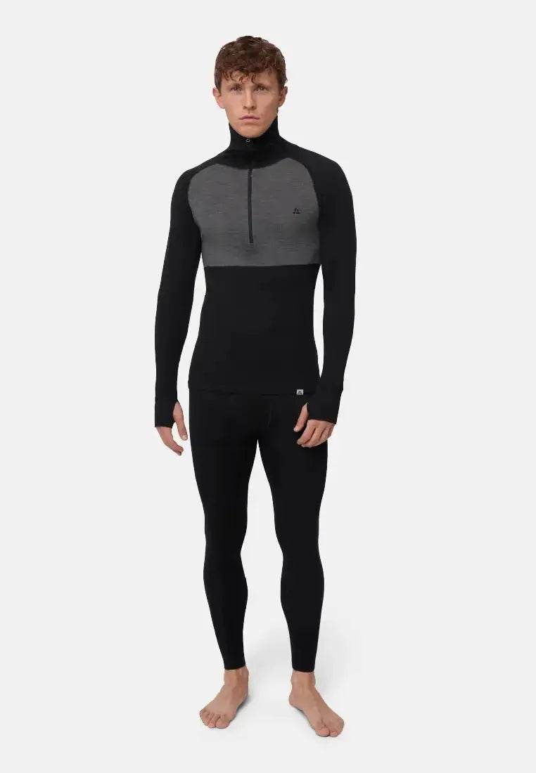 Man wearing a black and gray merino wool half-zip shirt and leggings, standing against a white background.