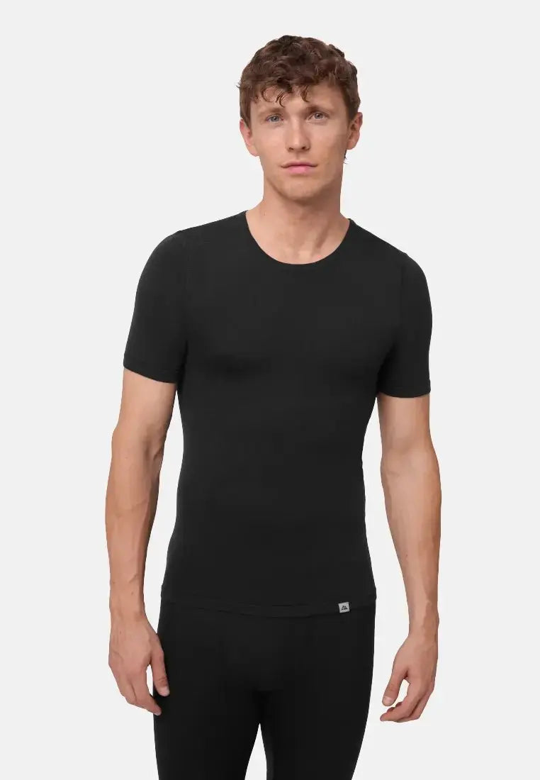 Man in a fitted black merino wool T-shirt, showcasing the base layer's snug fit and short sleeves.