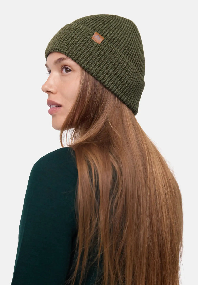 Olive green ribbed beanie with a leather patch worn by a person with long hair.