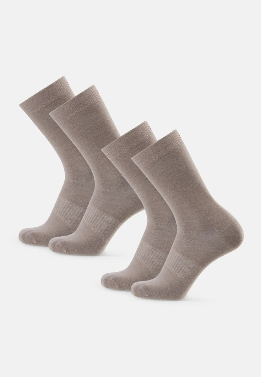Four beige merino wool hiking liner socks, arranged in two pairs on a white background.