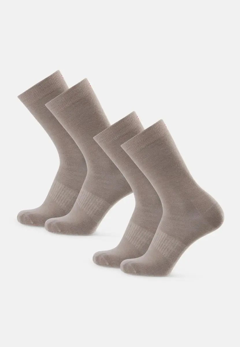 Four beige merino wool hiking liner socks, arranged in two pairs on a white background.
