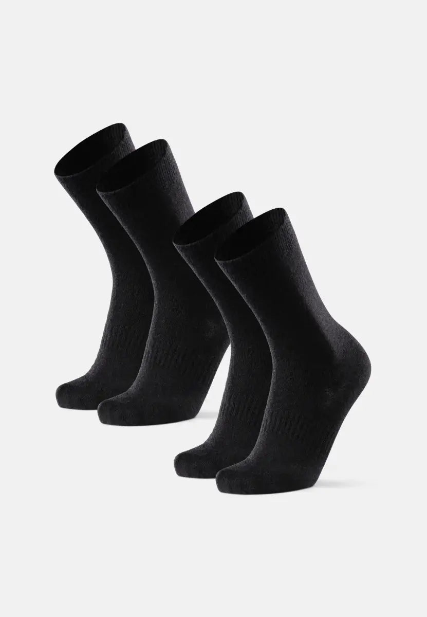 Four black merino wool socks, displayed in two pairs, standing upright on a white background.