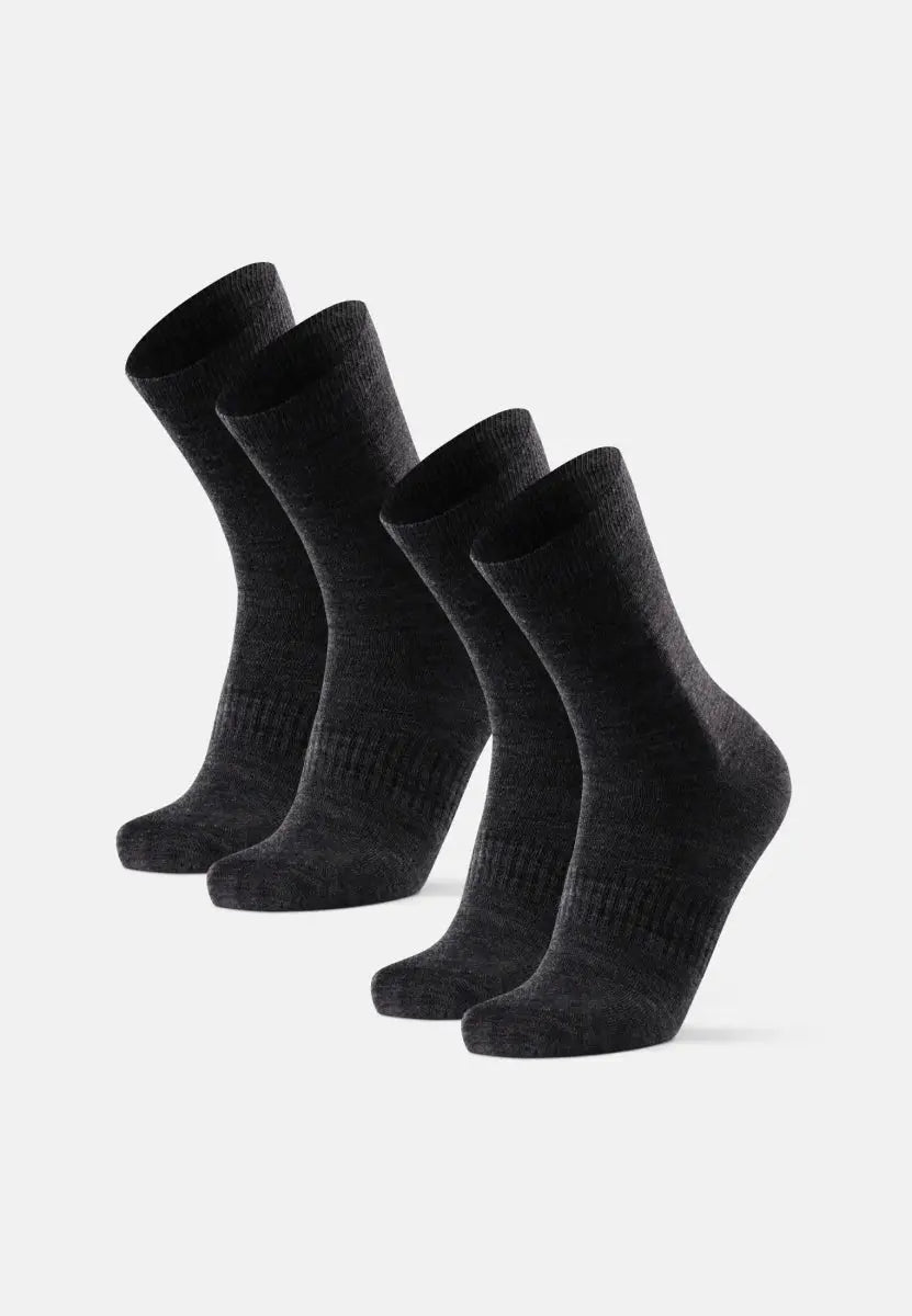 Four dark gray Merino wool socks standing upright, showcasing their texture against a white background.