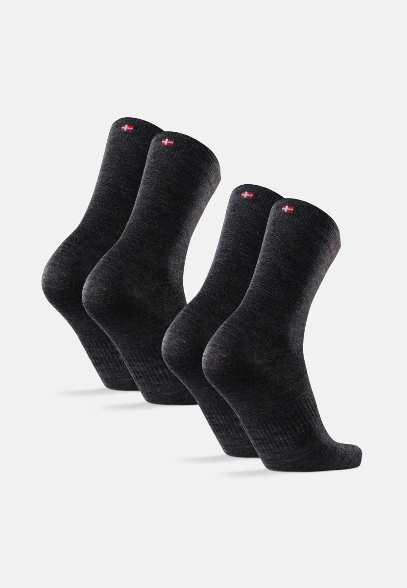 Four dark gray merino wool socks with red and white flag emblem on cuffs.