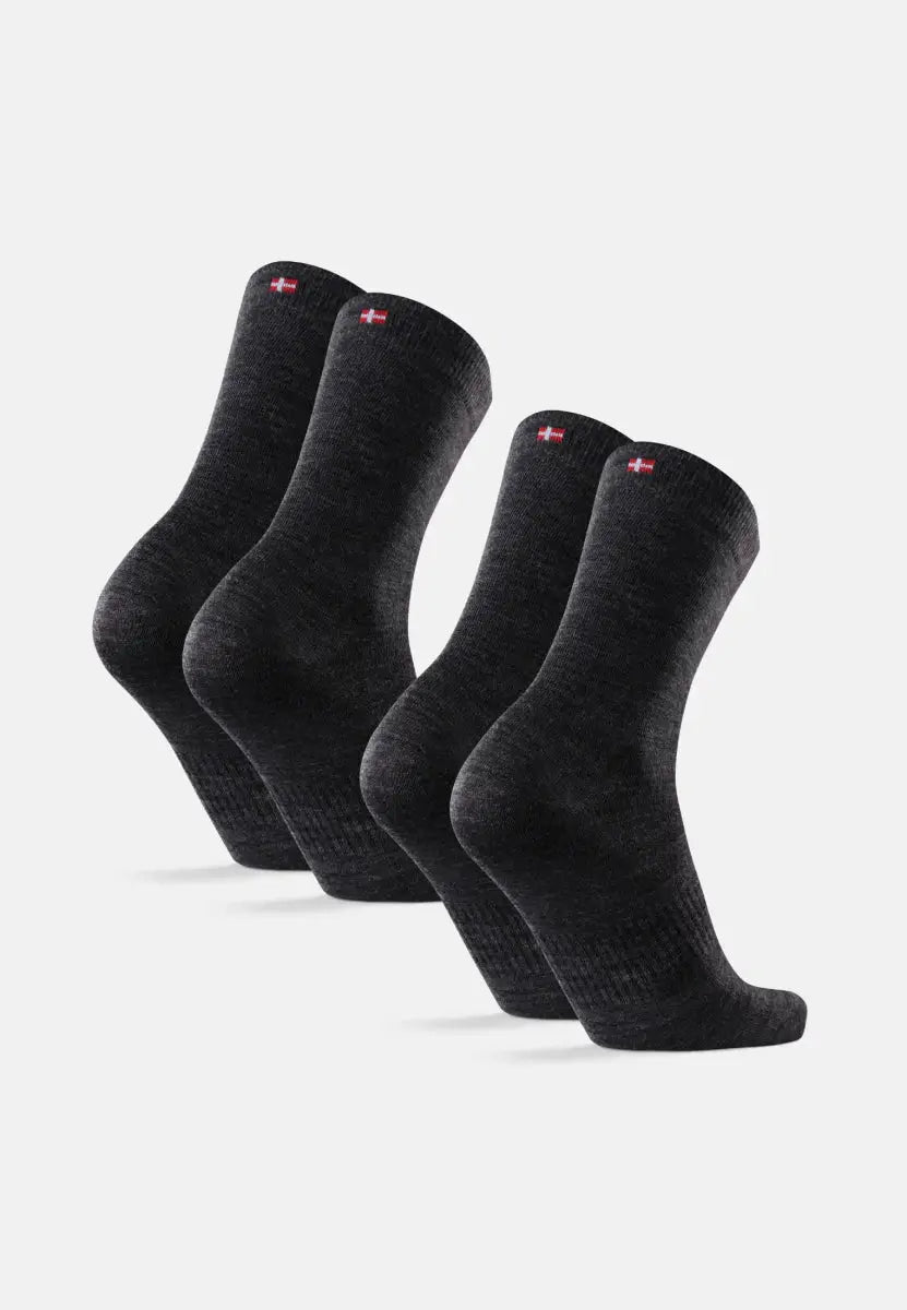 Four dark gray merino wool socks with red and white flag emblem on cuffs.