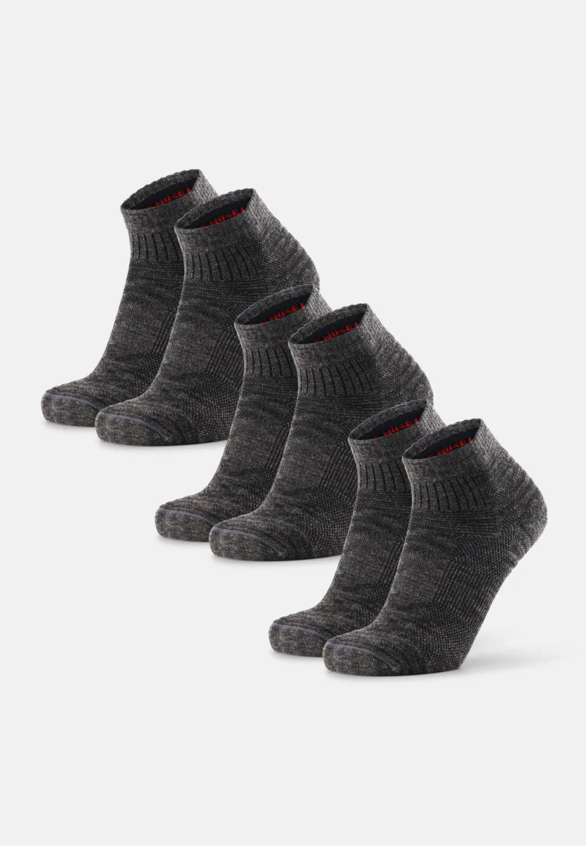 Five pairs of dark gray, low-cut merino wool hiking socks in a neat row.