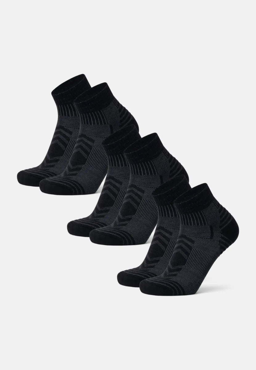 Five pairs of black merino wool low-cut hiking socks, arranged in a neat row.