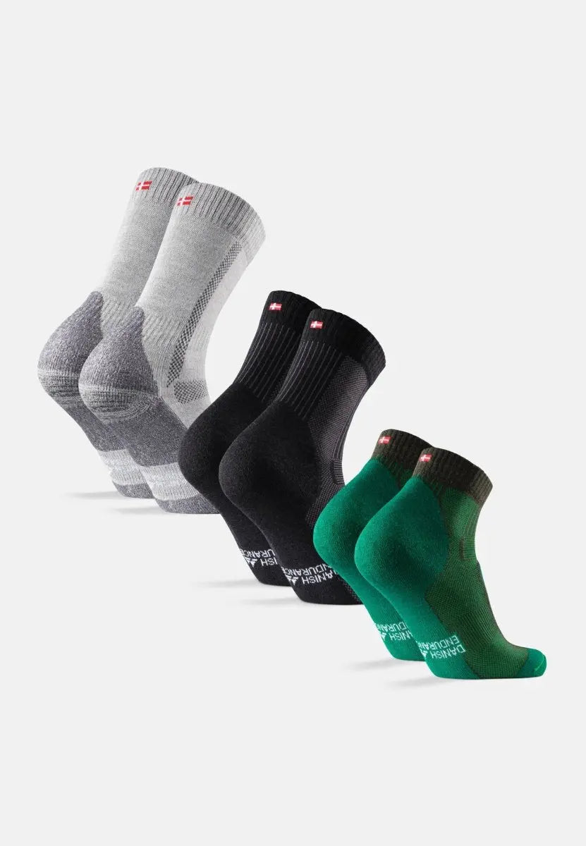Three pairs of socks in gray, black, and green, each with a small flag detail on the cuff.