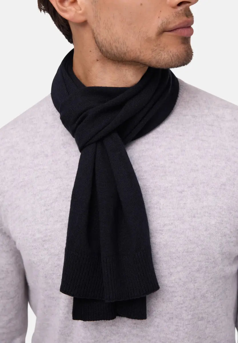 Dark merino wool scarf wrapped around neck, worn with a light gray sweater.