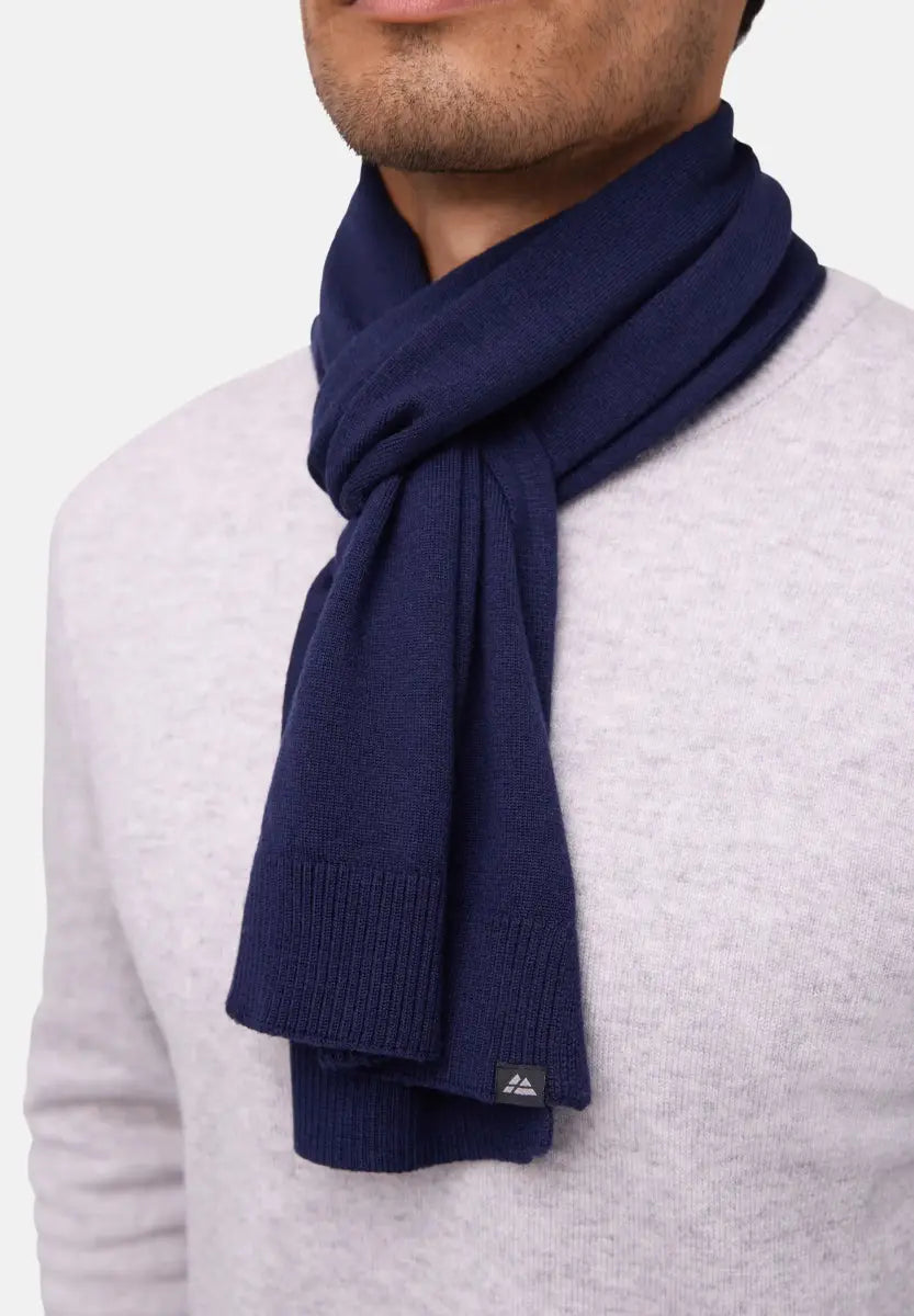 Navy blue merino wool scarf wrapped around neck, paired with a light gray sweater.