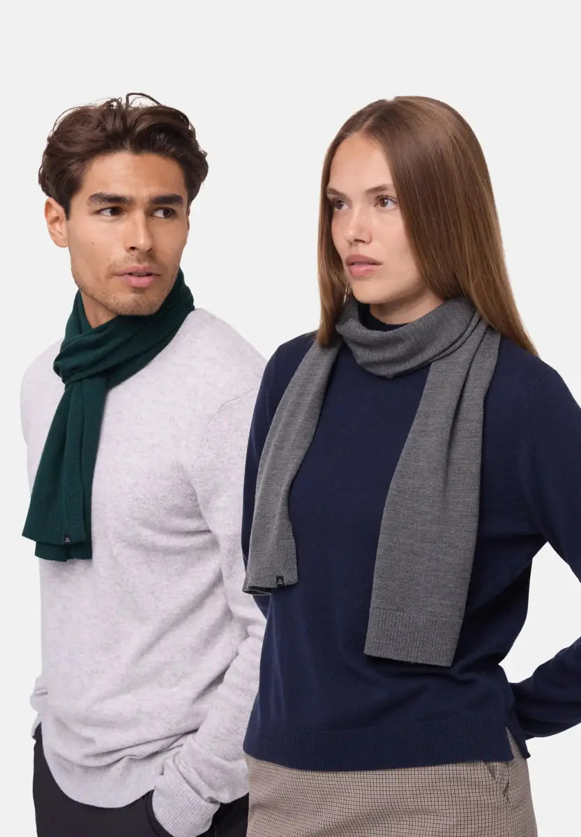 Two people wearing merino wool scarves; one green, the other gray, with neutral expressions.