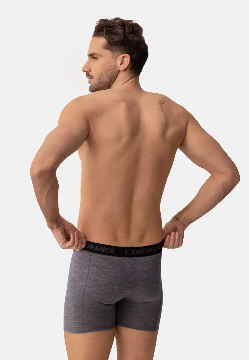 Man wearing gray merino wool trunks from behind, waistband reads "ENDURANCE."