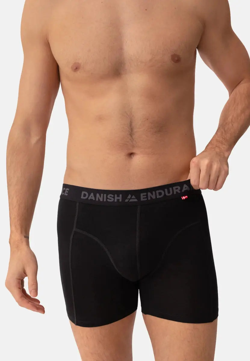 Man wearing black merino wool trunks with "DANISH ENDURANCE" on waistband.