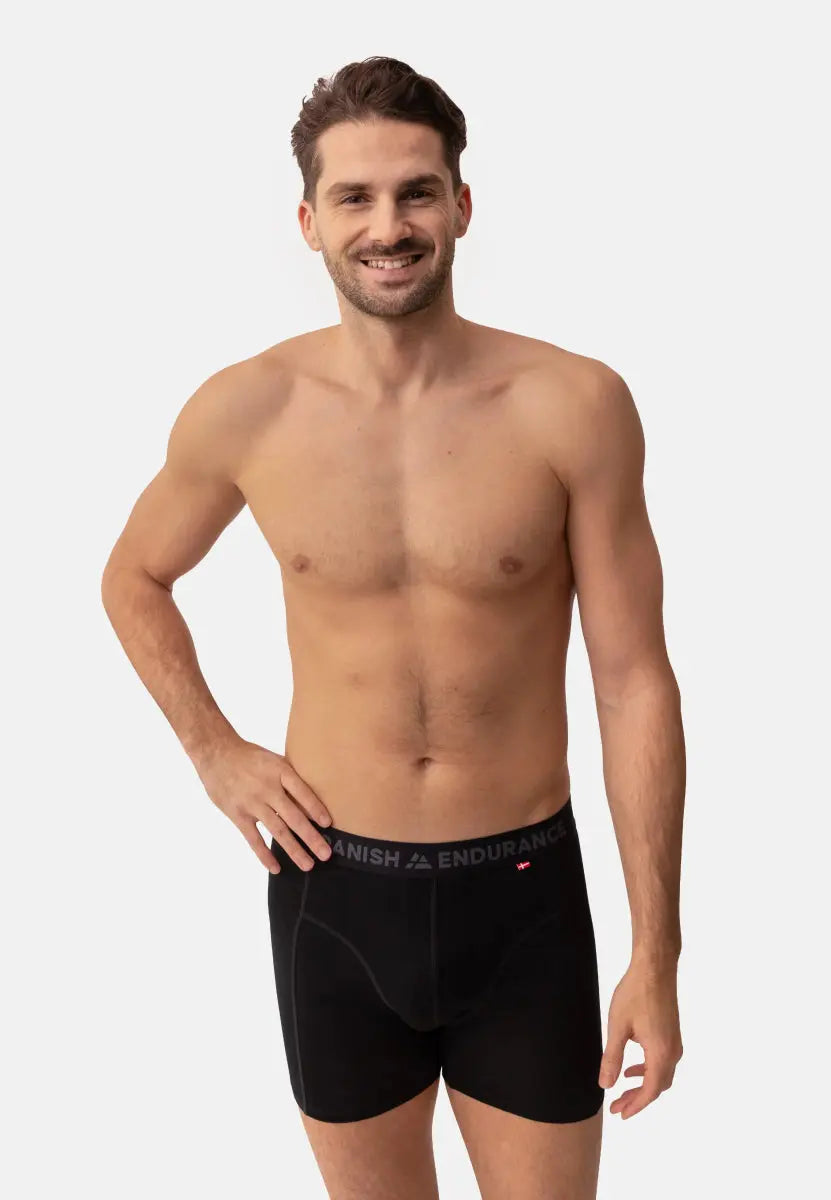 Man wearing black merino wool trunks with "Danish Endurance" on waistband, smiling.