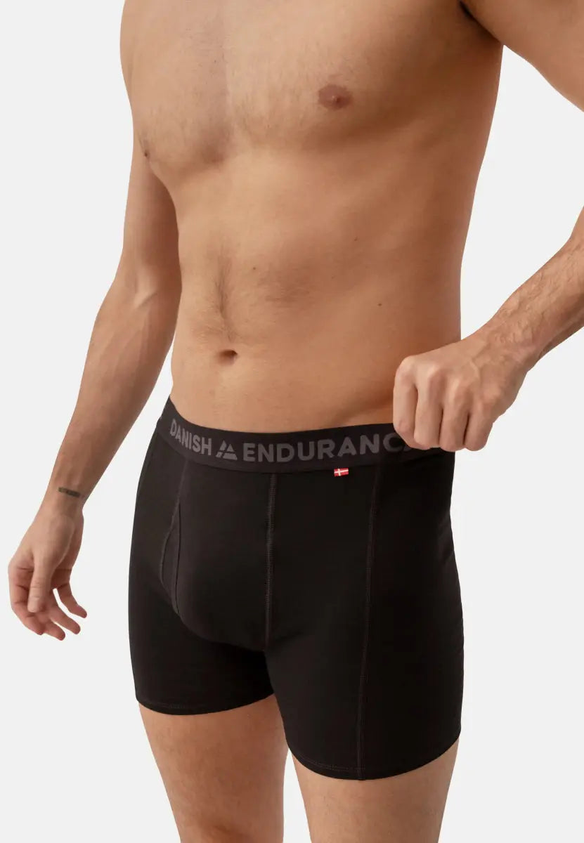 Man wearing black merino wool trunks with fly, branded waistband says "DANISH ENDURANCE".