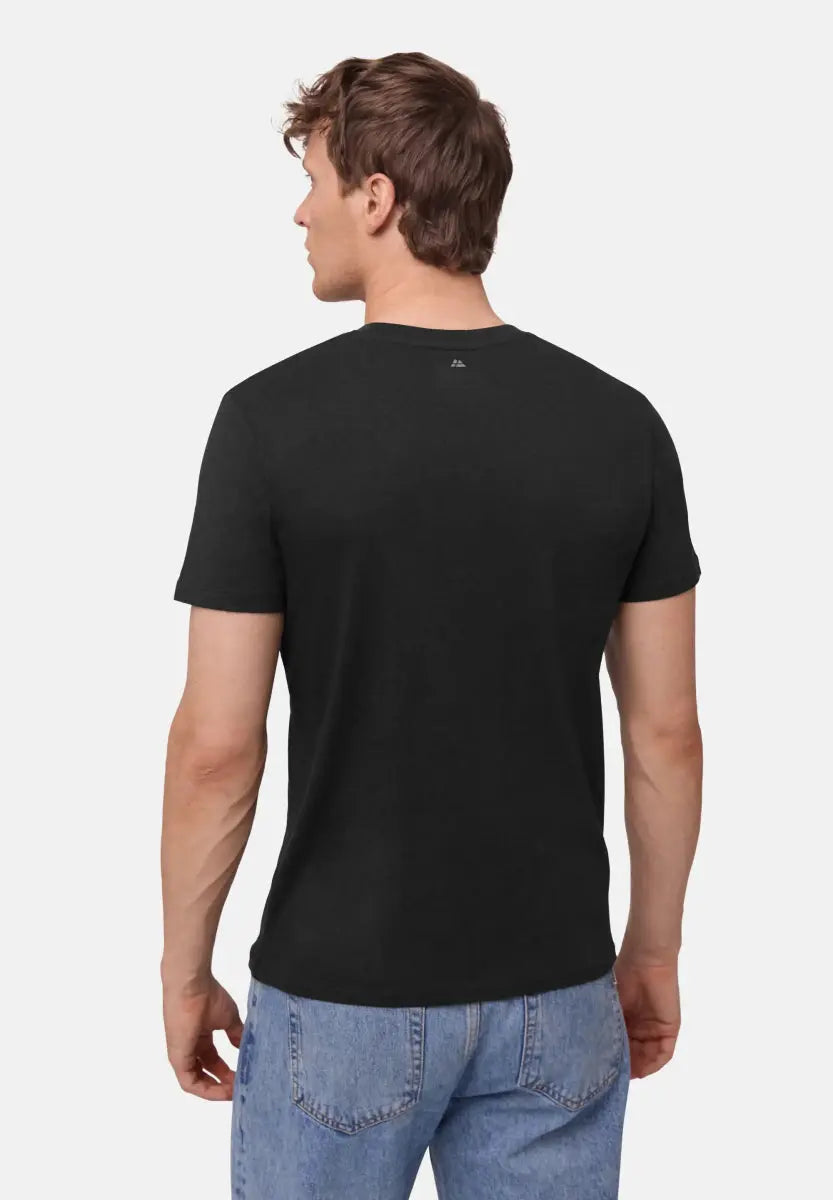 Man wearing a black crew neck t-shirt and light blue jeans, viewed from the back.