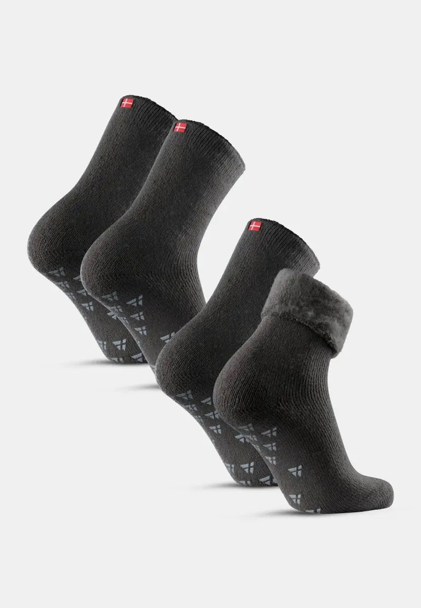 Four dark gray non-slip socks with plush lining and red flag detail on cuffs.