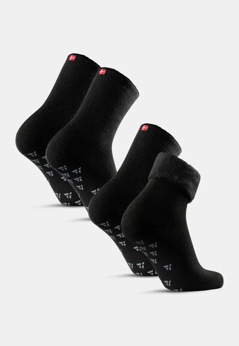 Four pairs of black non-slip socks with red tags and patterned soles, displayed in a row.